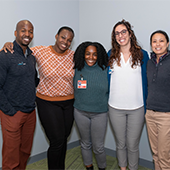 Group of five DPT of Color Panel Event attendees standing against a grey wall
